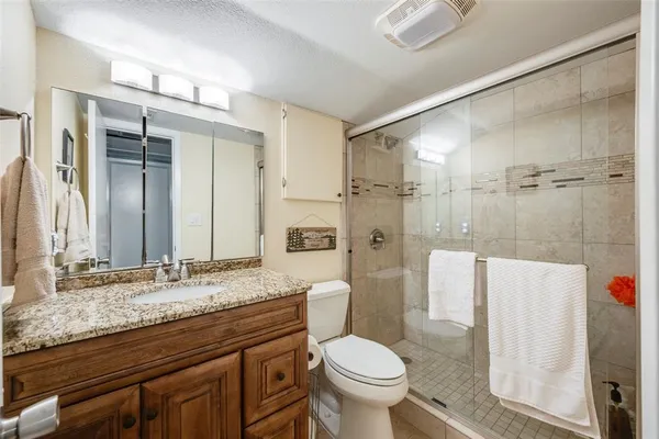 a bathroom with a granite countertop sink toilet and shower