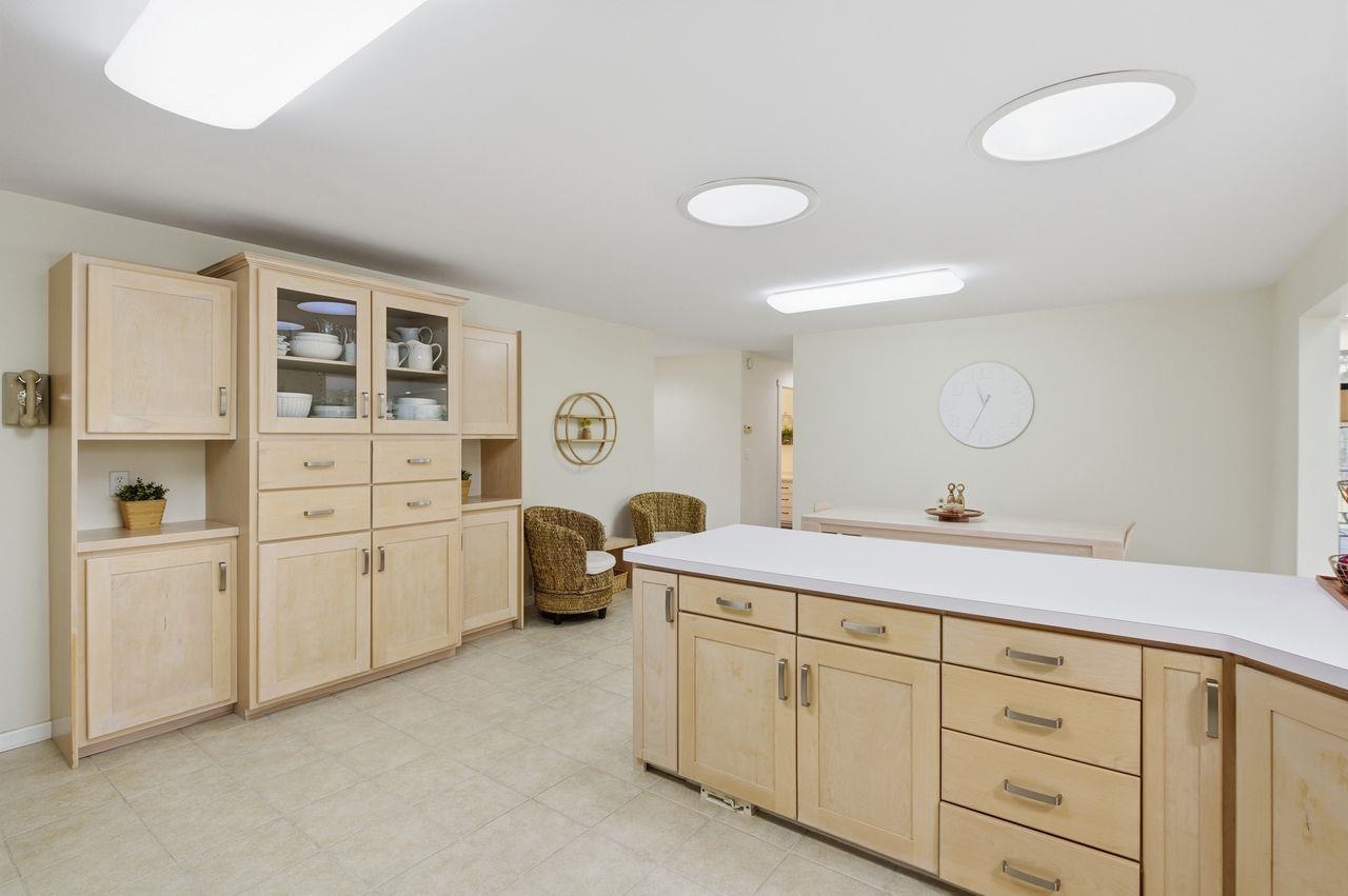 64903 Charles Johnson Road Ashland, WI 54806 - Photo 15 of 52 Kitchen featuring light brown cabinets, glass insert cabinets, and light countertops