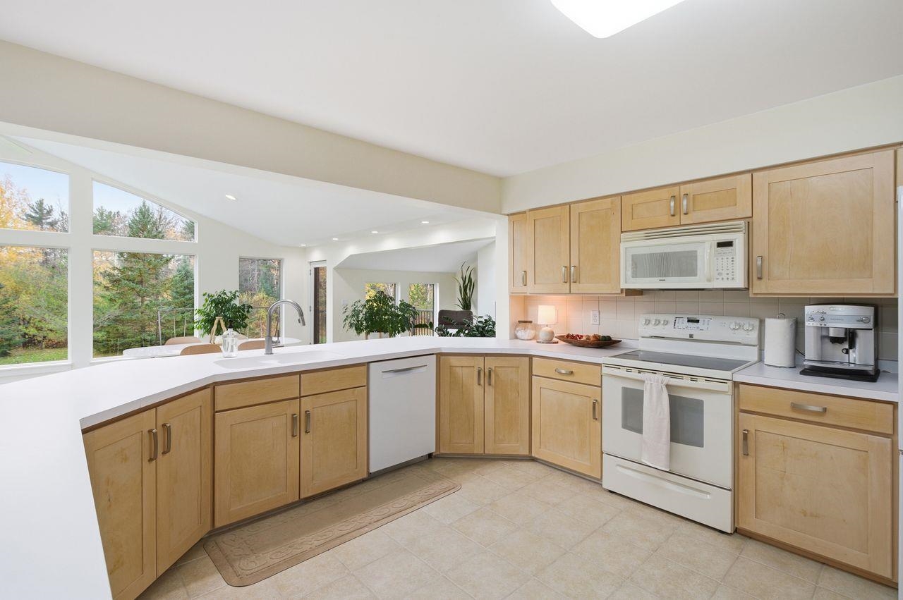 64903 Charles Johnson Road Ashland, WI 54806 - Photo 16 of 52 Kitchen featuring light brown cabinets, white appliances, light countertops, backsplash, and recessed lighting