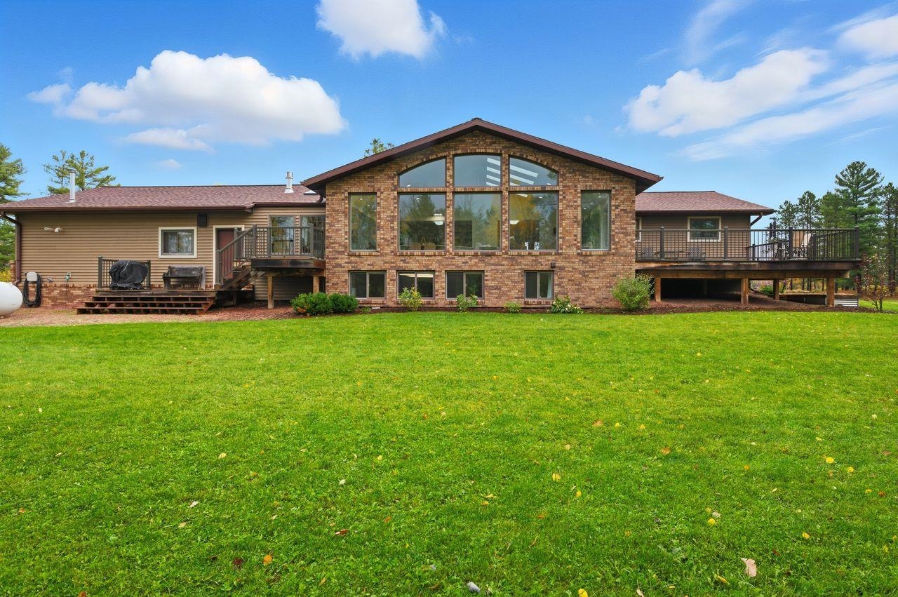 64903 Charles Johnson Road Ashland, WI 54806 - Photo 3 of 52 Back of property with a deck, a lawn, brick siding, and stairway