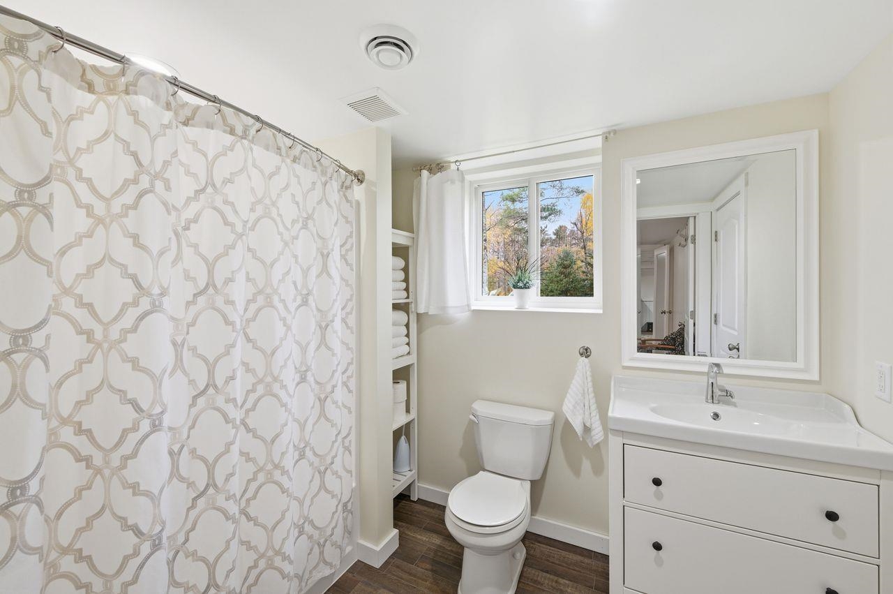 64903 Charles Johnson Road Ashland, WI 54806 - Photo 32 of 52 Bathroom featuring curtained shower, vanity, and dark wood-style floors