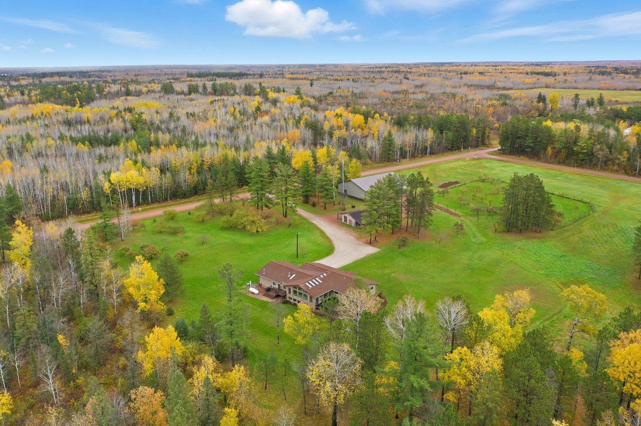 64903 Charles Johnson Road Ashland, WI 54806 - Photo 46 of 52 Aerial view of property and surrounding area with a heavily wooded area