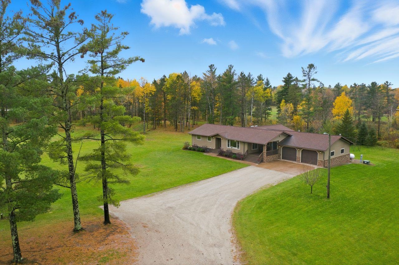 64903 Charles Johnson Road Ashland, WI 54806 - Photo 47 of 52 View of front of home with dirt driveway, a porch, stone siding, an attached garage, and a front yard