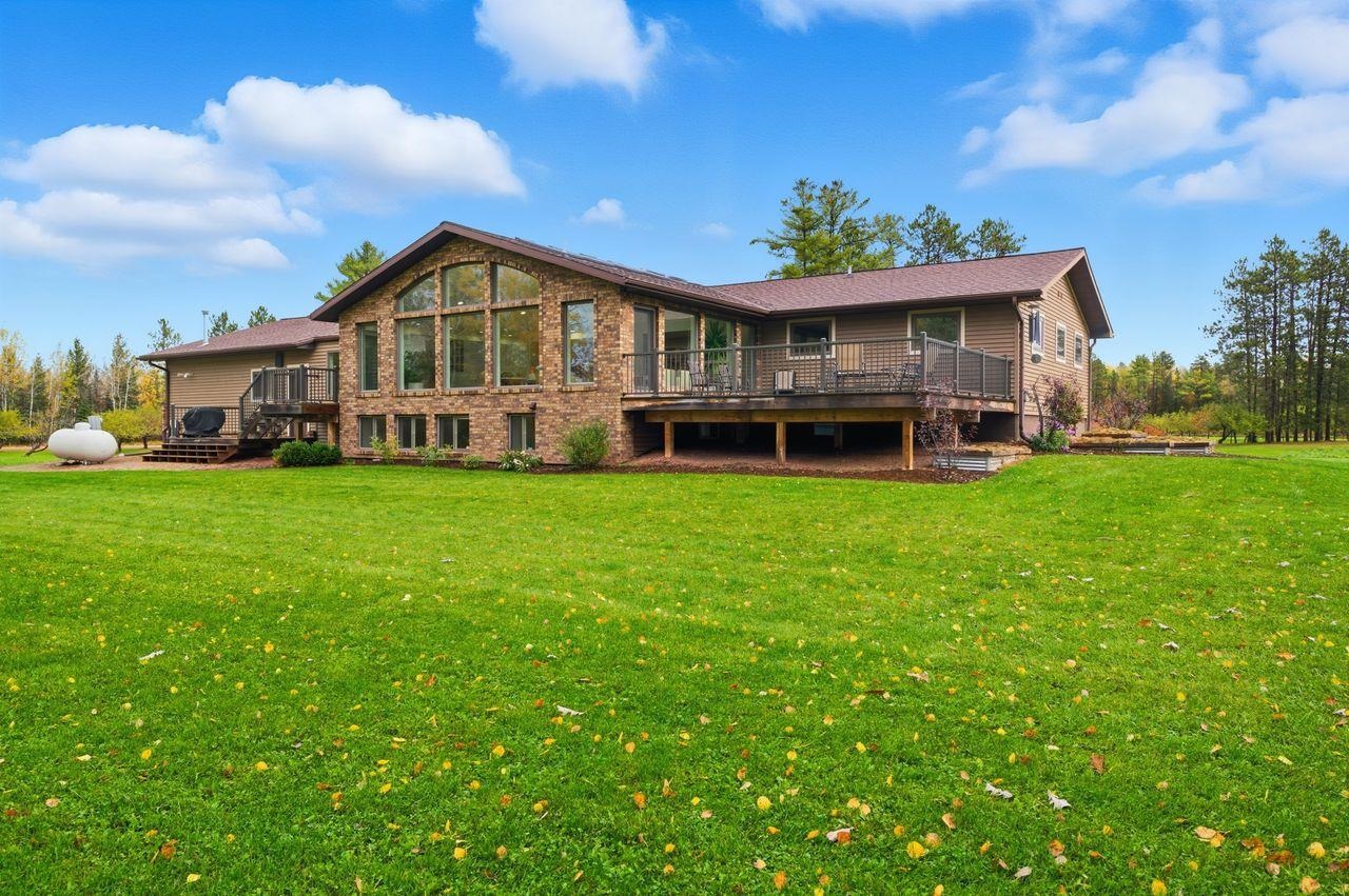 64903 Charles Johnson Road Ashland, WI 54806 - Photo 48 of 52 Rear view of house featuring a deck and a lawn