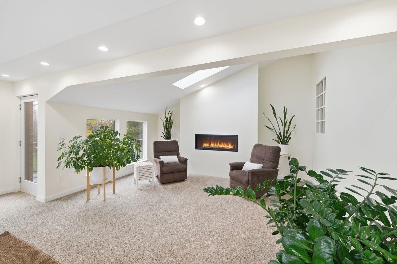 64903 Charles Johnson Road Ashland, WI 54806 - Photo 5 of 52 Living area with vaulted ceiling, carpet floors, a glass covered fireplace, a skylight, and recessed lighting