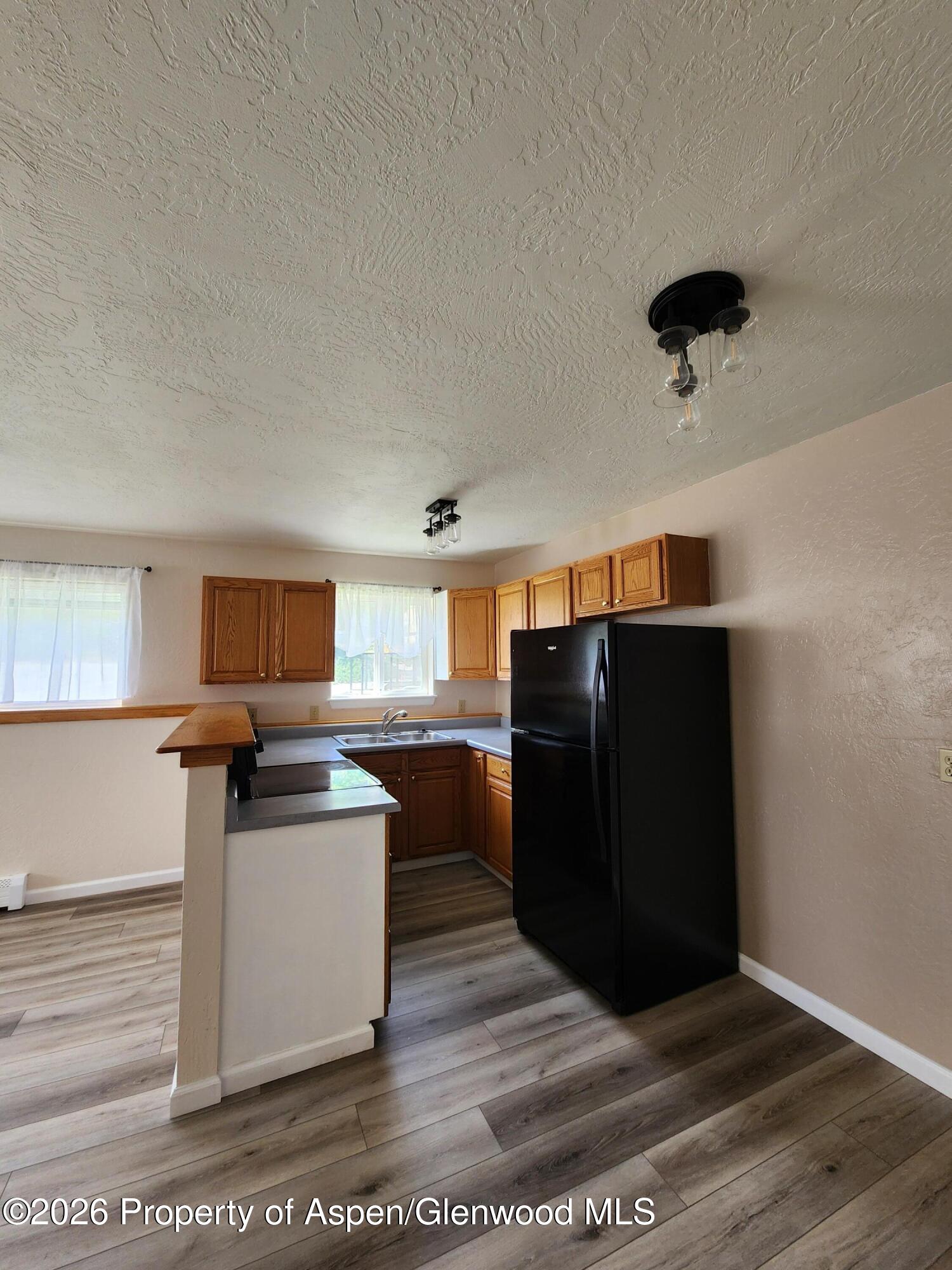 883 Taugenbaugh Boulevard Rifle, CO 81650 - Photo 10 of 18 a kitchen with a refrigerator and cabinets