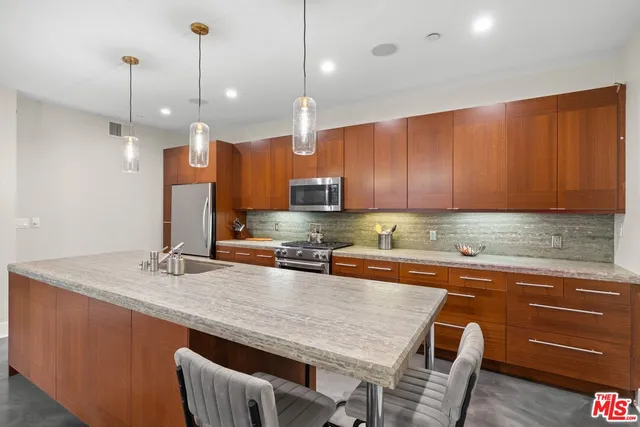 a kitchen with stainless steel appliances granite countertop a sink a stove and a wooden floors