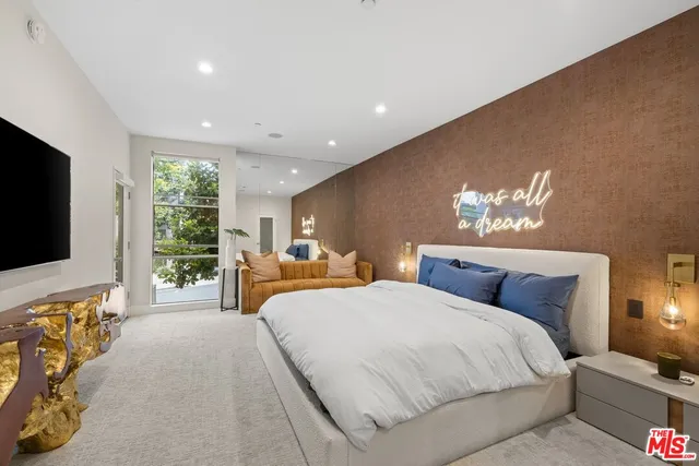 a bedroom with bed and a flat screen tv