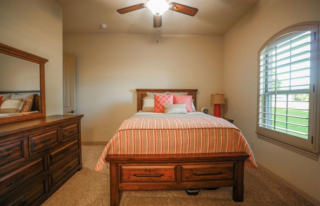1387 Shadow Lakes Drive Wills Point, TX 75169 - Photo 21 of 33 a bedroom with a bed and a chandelier
