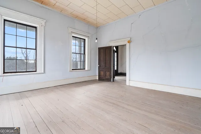 a view of empty room with wooden floor and fireplace