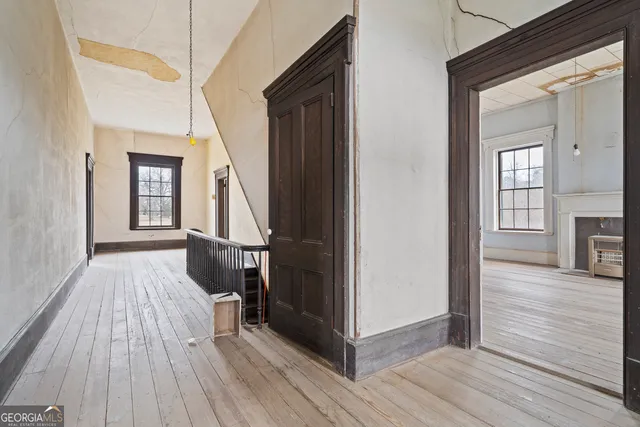 an empty room with wooden floor and a fireplace