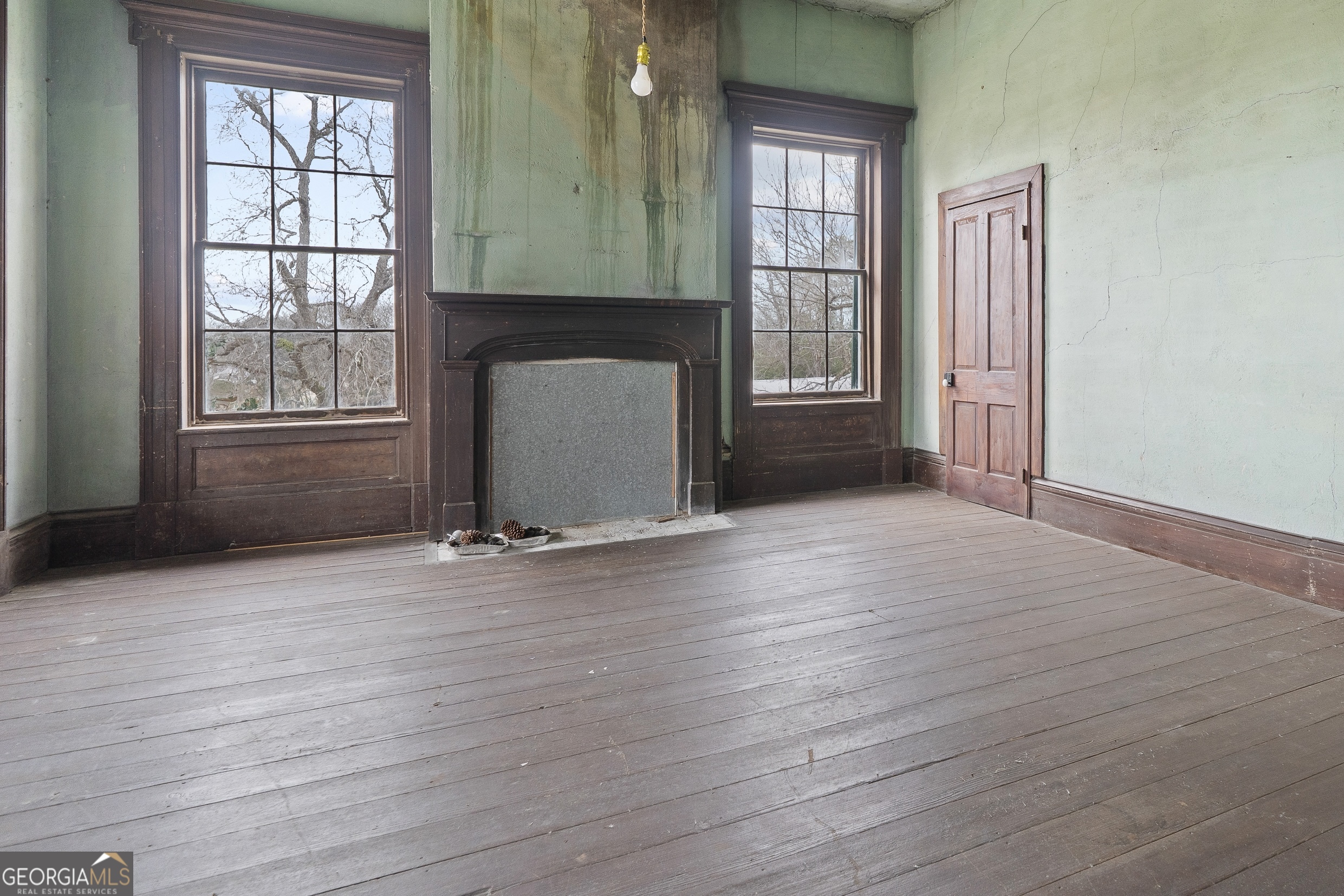 12871 Linton Road Sparta, GA 31087 - Photo 15 of 52 an empty room with wooden floor and a fireplace