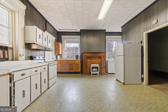 a kitchen with white cabinets and white appliances