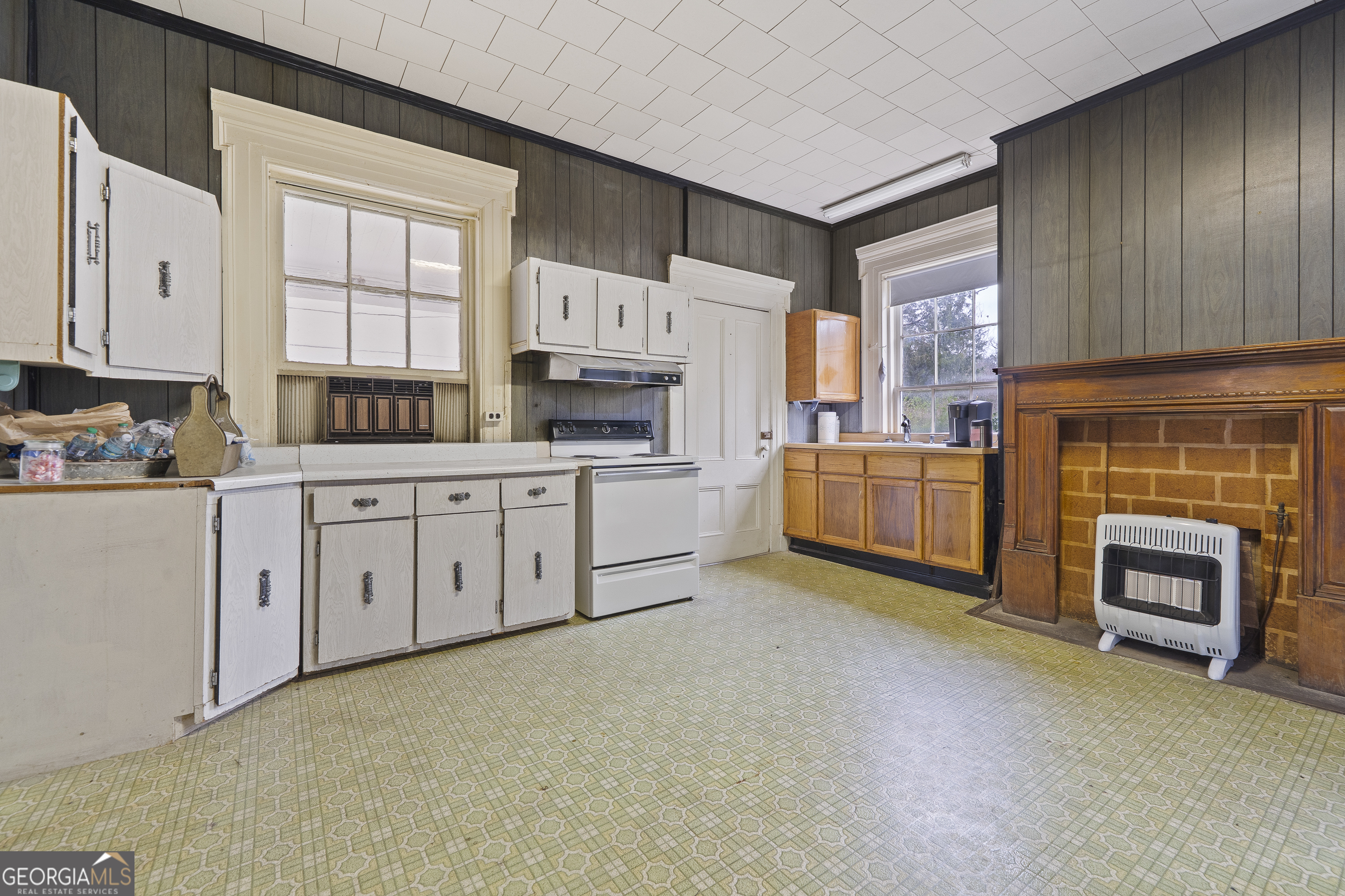12871 Linton Road Sparta, GA 31087 - Photo 27 of 52 a kitchen with white cabinets and white appliances