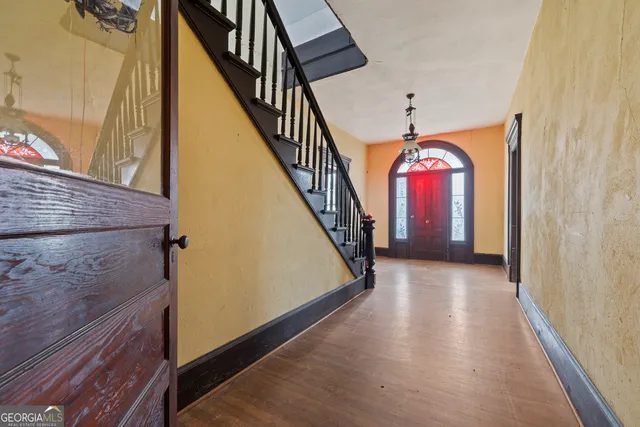 a view of a hallway with wooden floor and staircase