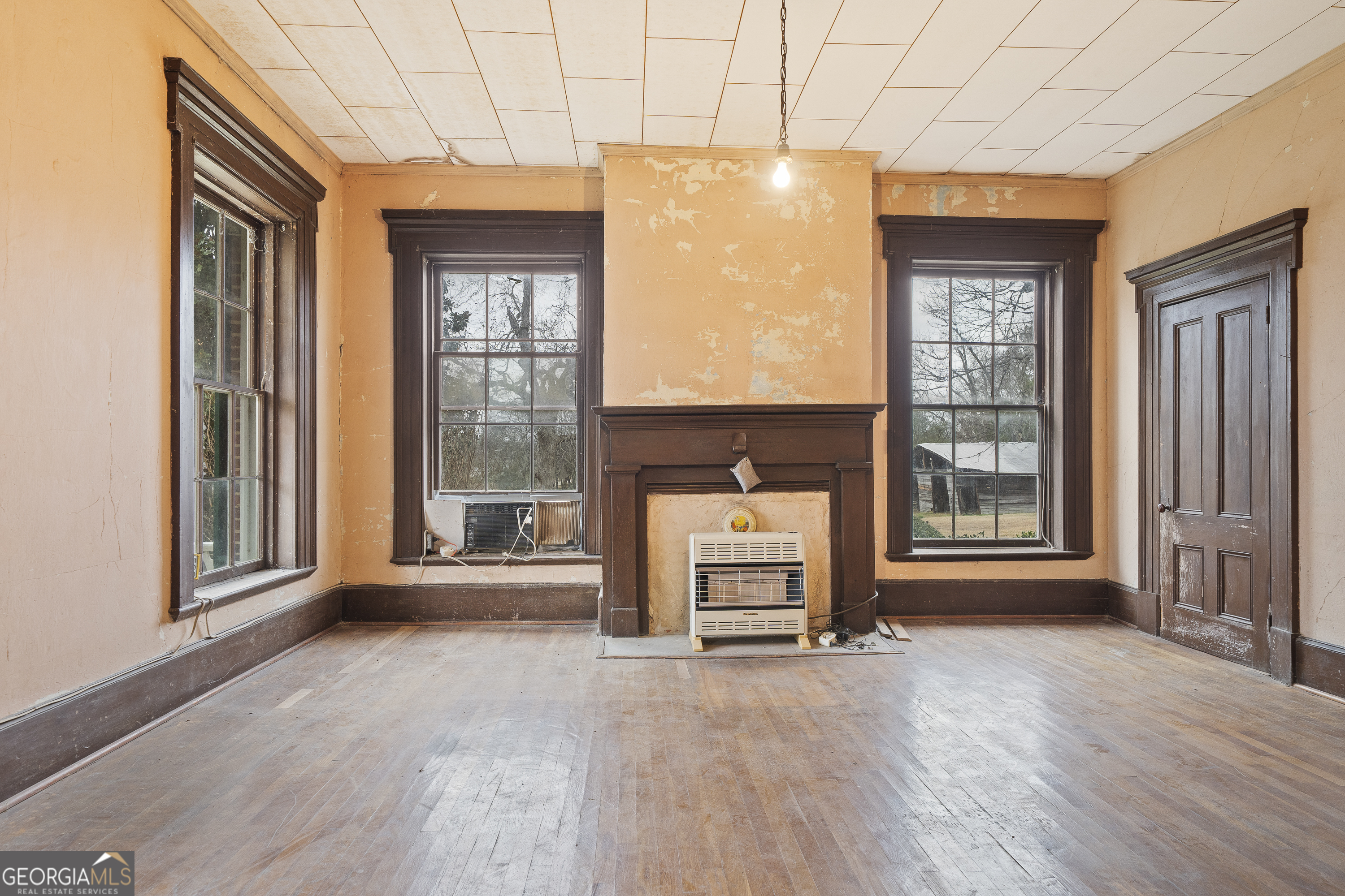 12871 Linton Road Sparta, GA 31087 - Photo 38 of 52 an empty room with a fireplace and windows