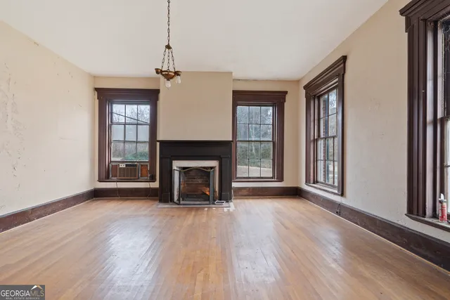 a view of a hallway with wooden floor and staircase