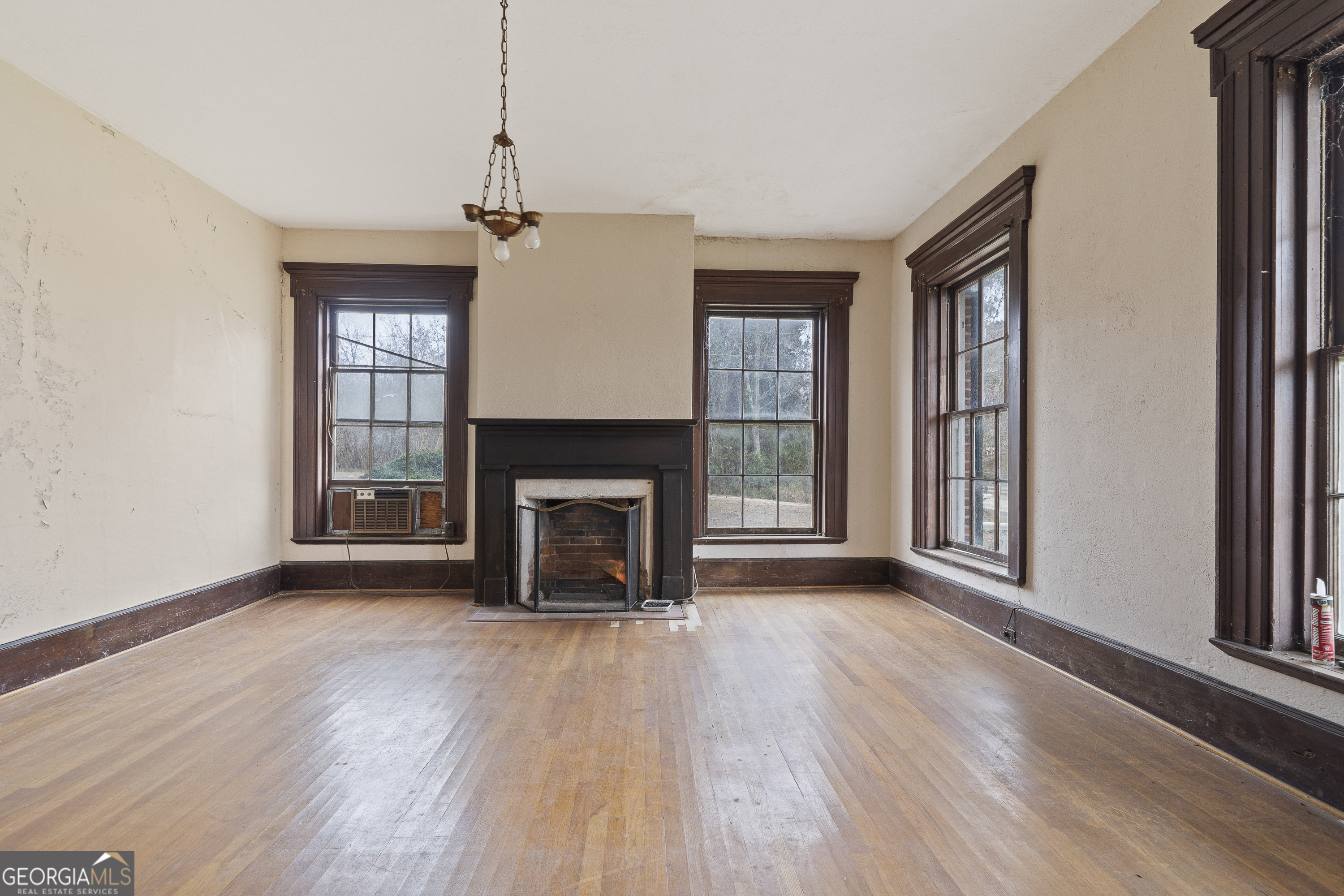 12871 Linton Road Sparta, GA 31087 - Photo 42 of 52 a view of an empty room with wooden floor fireplace and a window