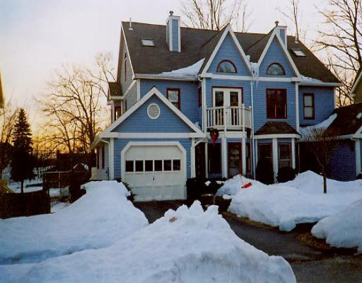 a view of a house with a yard covered in snow