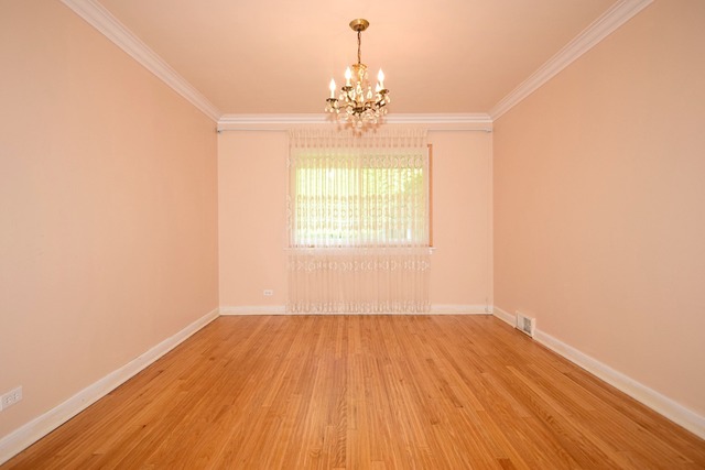 439 Shenstone Road Riverside, IL 60546 - Photo 8 of 25 an empty room with wooden floor chandelier and windows