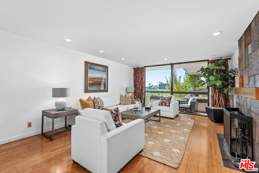 851 North Kings Road, Unit 307 West Hollywood, CA 90069 - Photo 11 of 38 a living room with furniture large windows and a flat screen tv