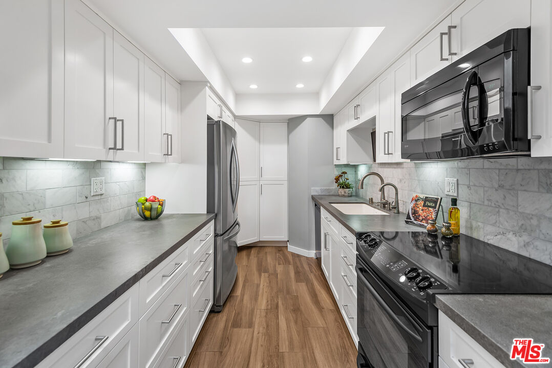 851 North Kings Road, Unit 307 West Hollywood, CA 90069 - Photo 14 of 38 a kitchen with sink a stove and cabinets