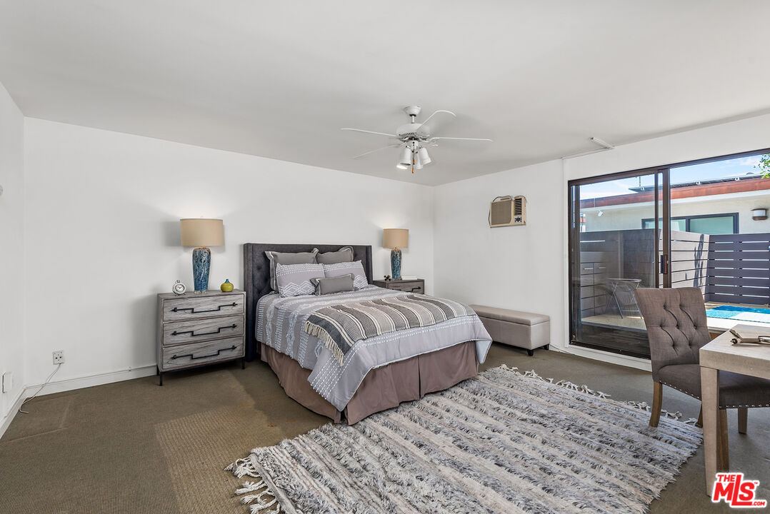 851 North Kings Road, Unit 307 West Hollywood, CA 90069 - Photo 26 of 38 a bedroom with a bed and wooden floor