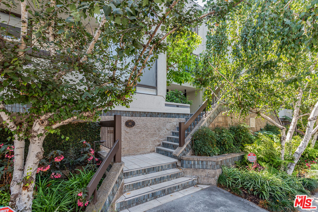 851 North Kings Road, Unit 307 West Hollywood, CA 90069 - Photo 3 of 38 a view of a house with a tree and flower plants