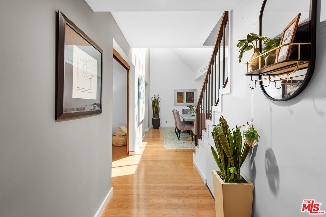 851 North Kings Road, Unit 307 West Hollywood, CA 90069 - Photo 4 of 38 a hallway with a dining table and a chandelier