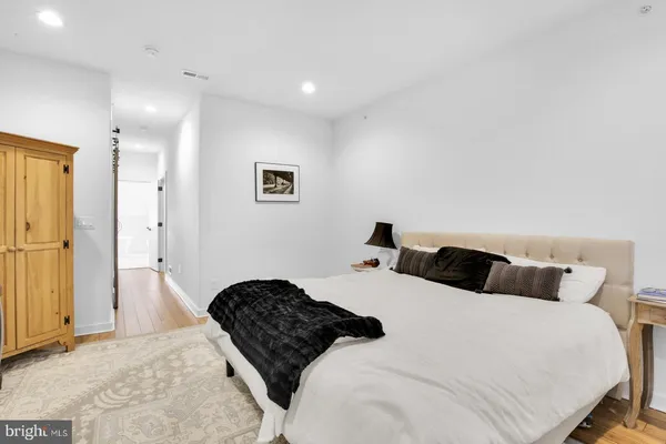 a bedroom with a bed and painting on the wall