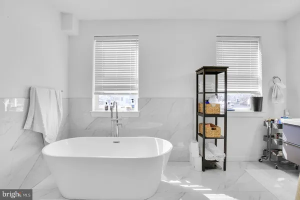 a white bath tub sitting in a bathroom next to a window