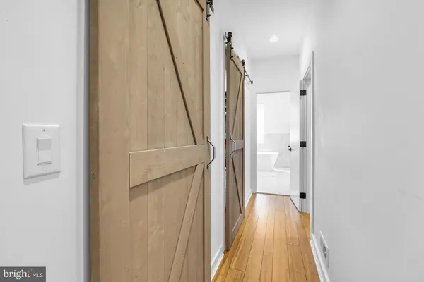 a view of a hallway with wooden floor and staircase