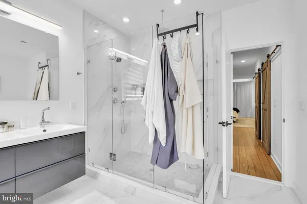 a bathroom with a shower sink and mirror