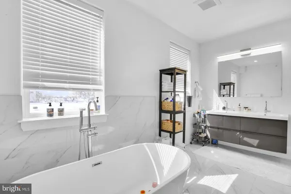 a bathroom with a tub sink and mirror