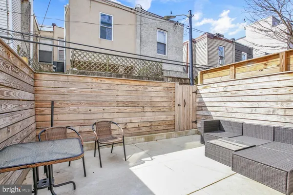 a view of a patio with couches table and chairs with wooden floor