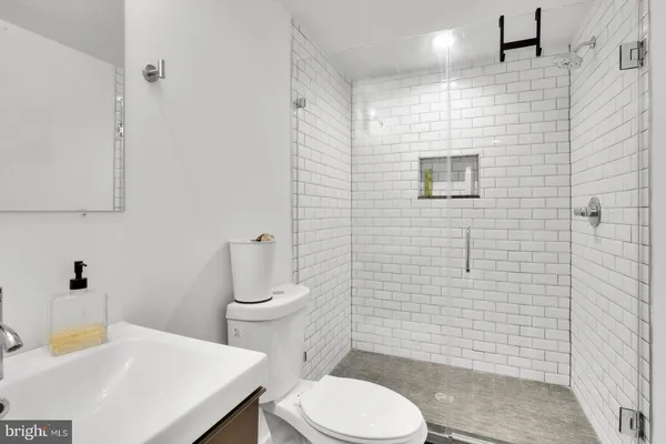 a bathroom with a sink a toilet and a mirror