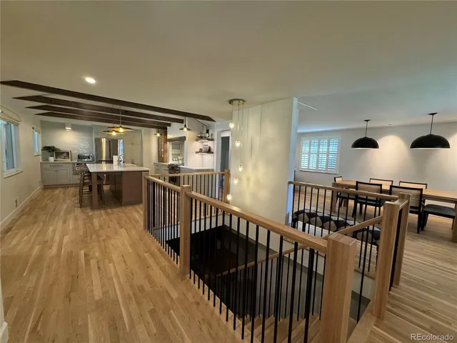 a view of a hallway with wooden floor and furniture