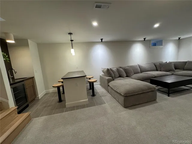 a kitchen with a sink chandelier and living room view