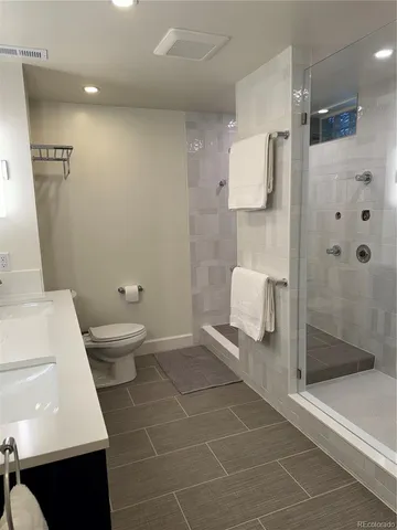 a bathroom with a double vanity sink toilet and shower