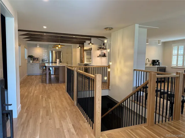 a view of a hallway with wooden floor and furniture