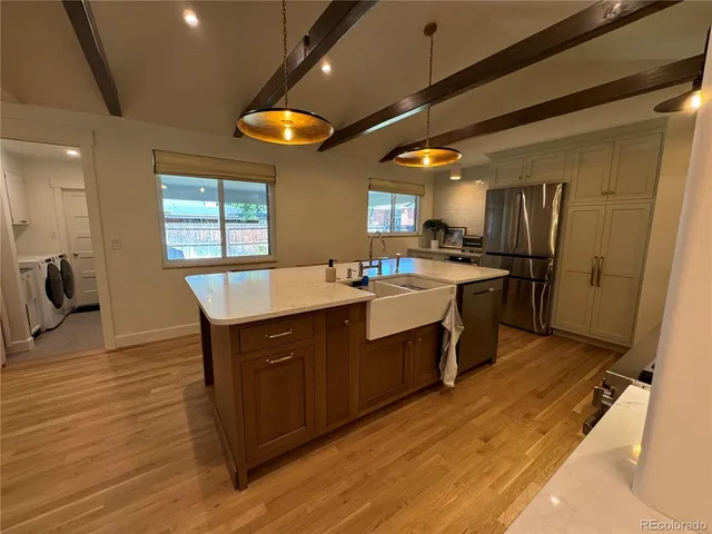 a kitchen with stainless steel appliances granite countertop a sink stove and refrigerator