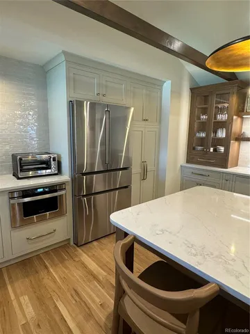 a kitchen with a wooden floor and a refrigerator