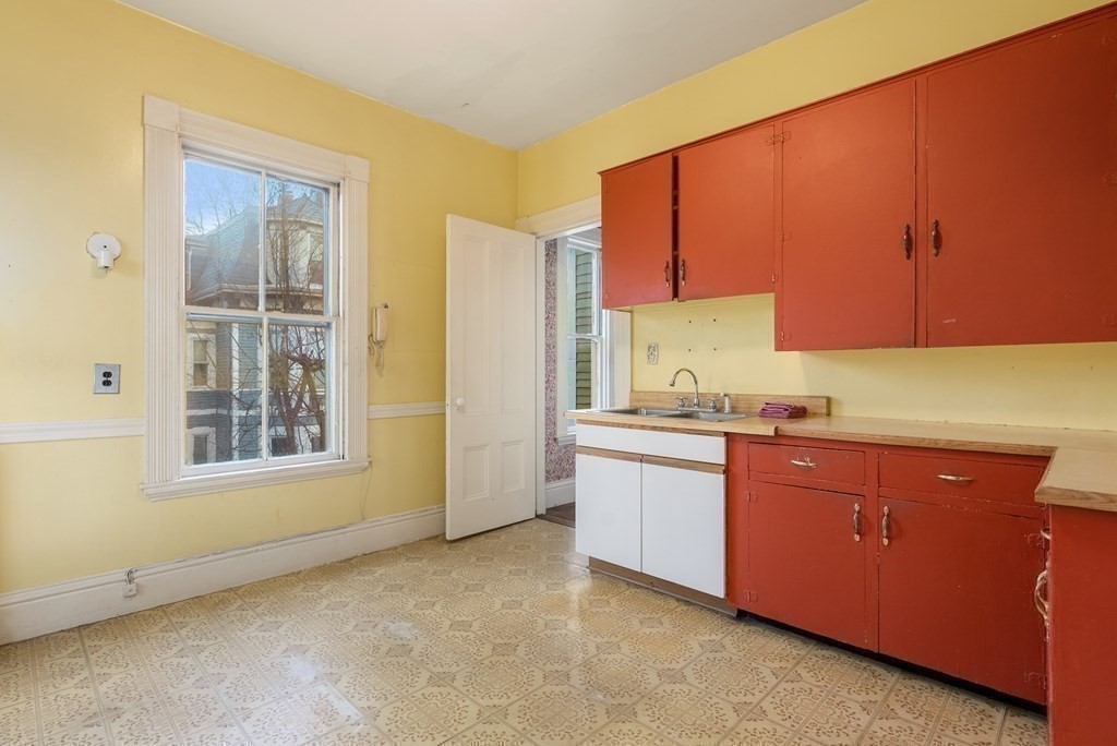 11 Gorham Avenue Brookline, MA 02445 - Photo 13 of 32 a kitchen with granite countertop a sink cabinets and a window