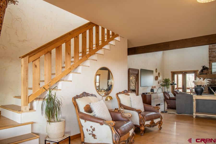 66961 Solar Road Montrose, CO 81403 - Photo 13 of 44 a living room with couches a dining table and chairs with wooden floor