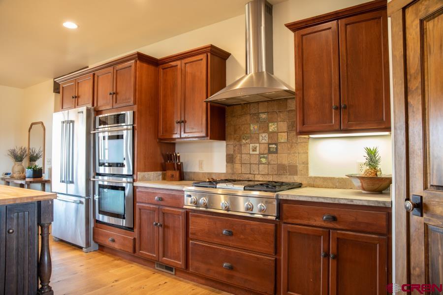 66961 Solar Road Montrose, CO 81403 - Photo 18 of 44 a kitchen with stainless steel appliances granite countertop a stove and a refrigerator