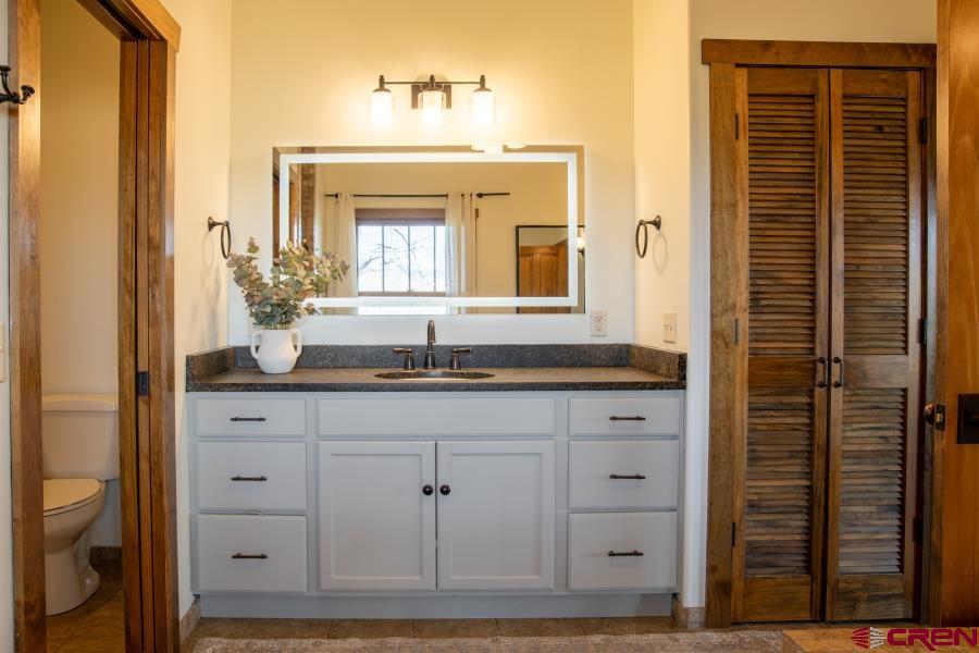 66961 Solar Road Montrose, CO 81403 - Photo 24 of 44 a bathroom with a granite countertop sink and a mirror