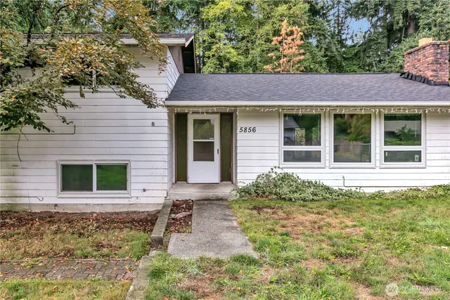 a view of house with outdoor space and trees in the background