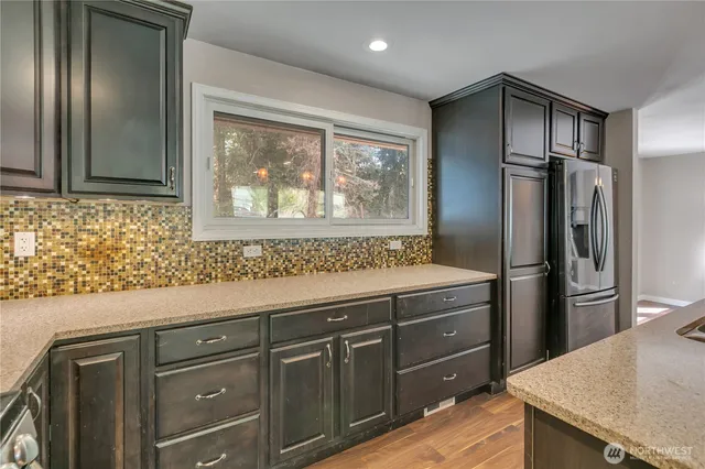 a kitchen with stainless steel appliances granite countertop a refrigerator and a sink