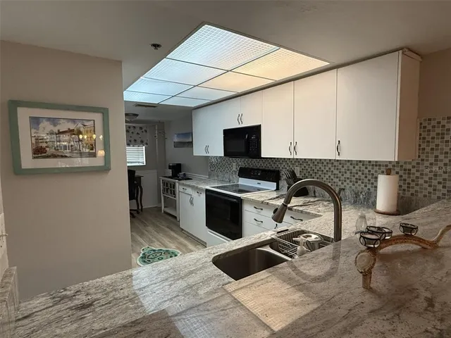 a kitchen with a sink appliances and cabinets