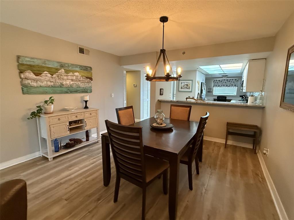 9510 Harbor Greens Way, Unit 407 Seminole, FL 33776 - Photo 13 of 41 a view of a dining room with furniture wooden floor and a chandelier